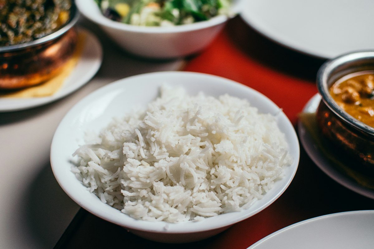 Travessa de arroz de forno colorido com queijo derretido, pedaços de frango e ervilhas