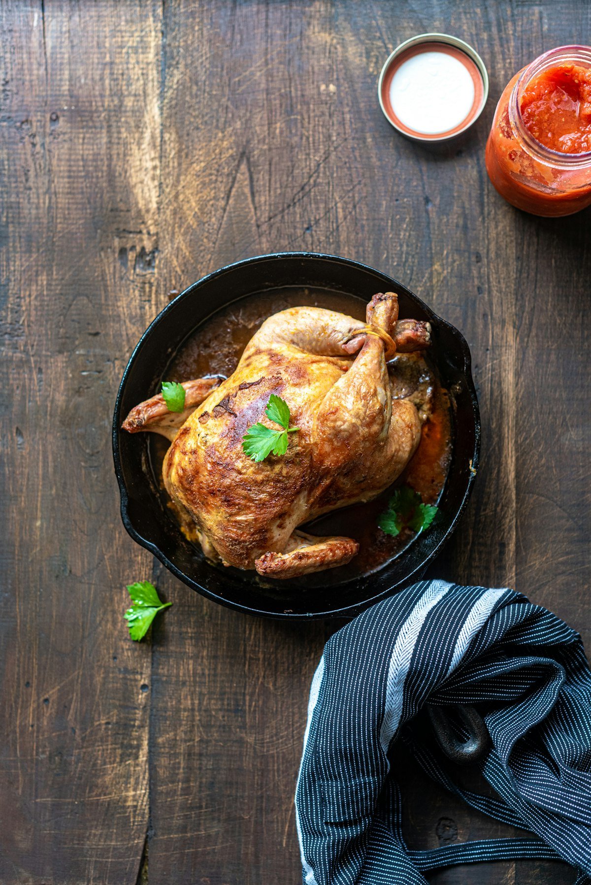Pedaços de frango assados com pele dourada e crocante acompanhados de batatas coradas e alecrim
