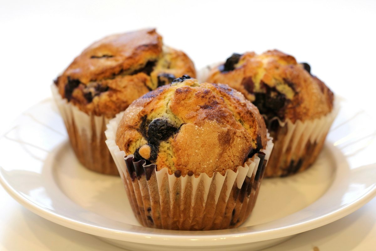 Bandeja com muffins saudáveis de banana com aveia e canela dourados e fumegantes